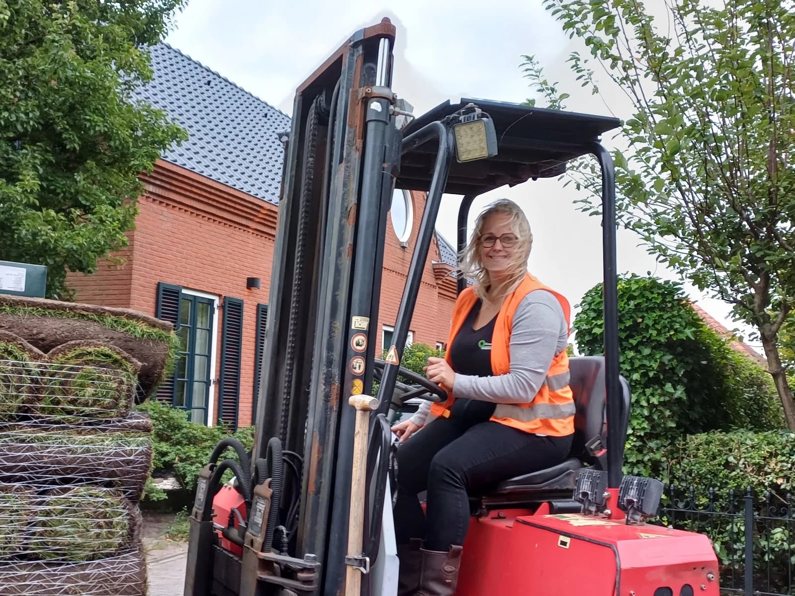 Miranda rijdt een pallet verse graszoden met de meeneemheftruck naar de tuin