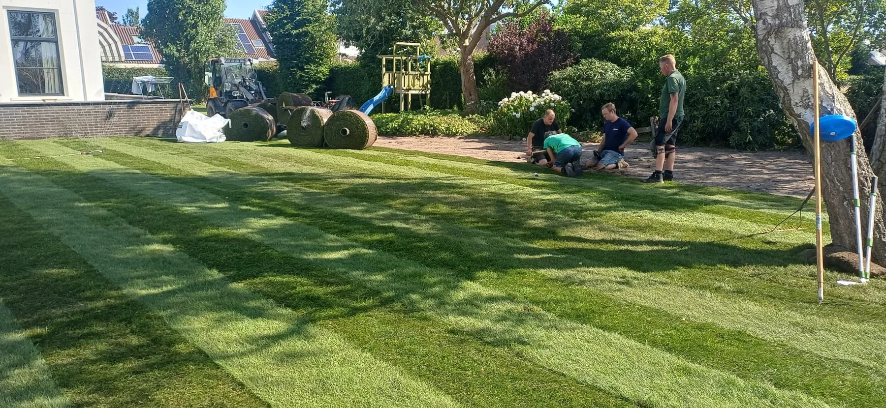 Ons team legt verse graszoden in een tuin