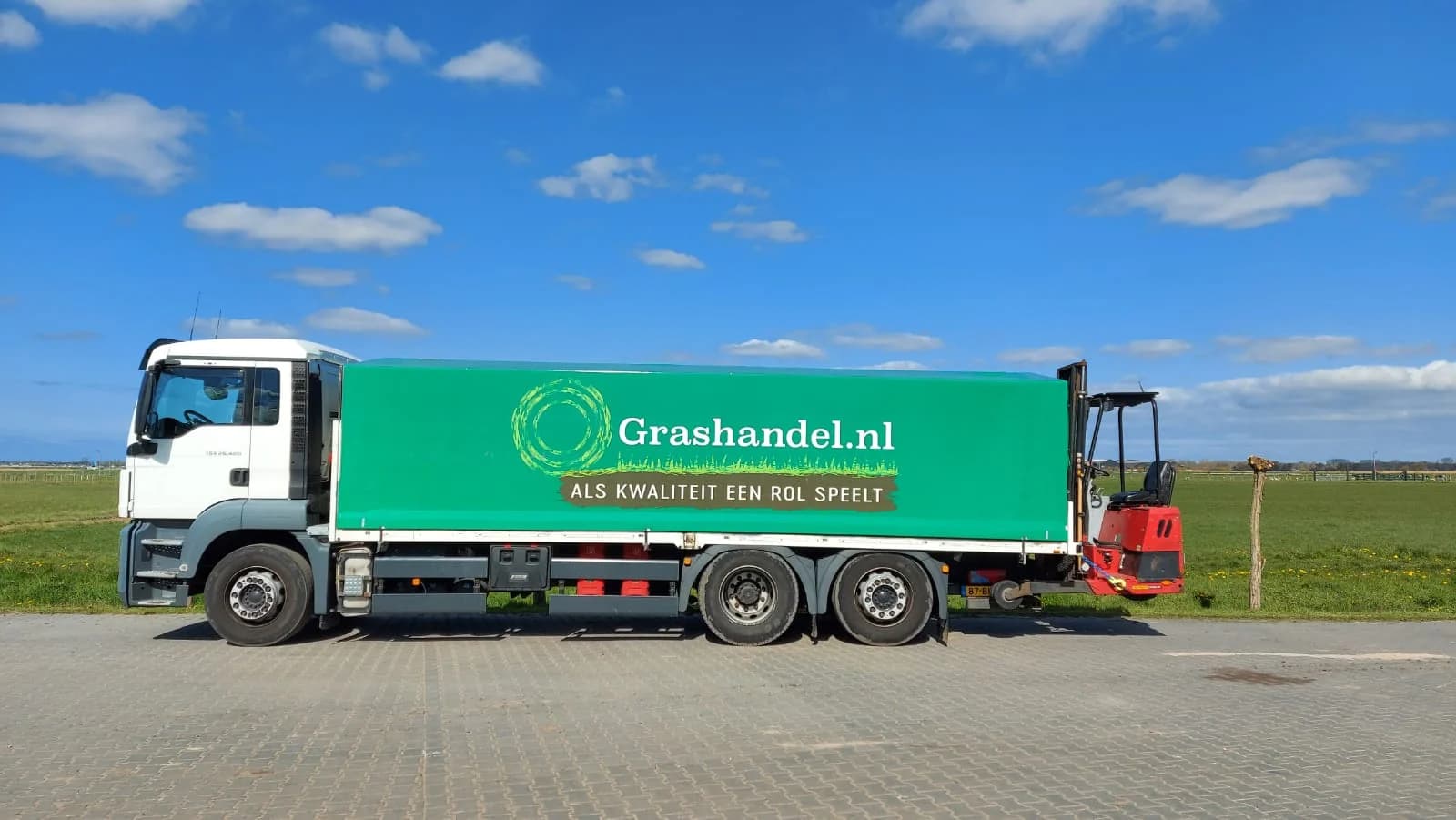 De vrachtwagen van Grashandel.nl met meeneemheftruck, klaar voor levering